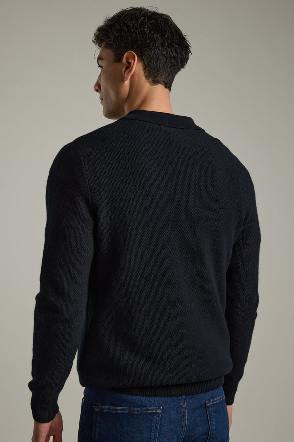 Man in Barkers Ainsley Woollen Long Sleeve Polo and blue jeans, facing away from camera.