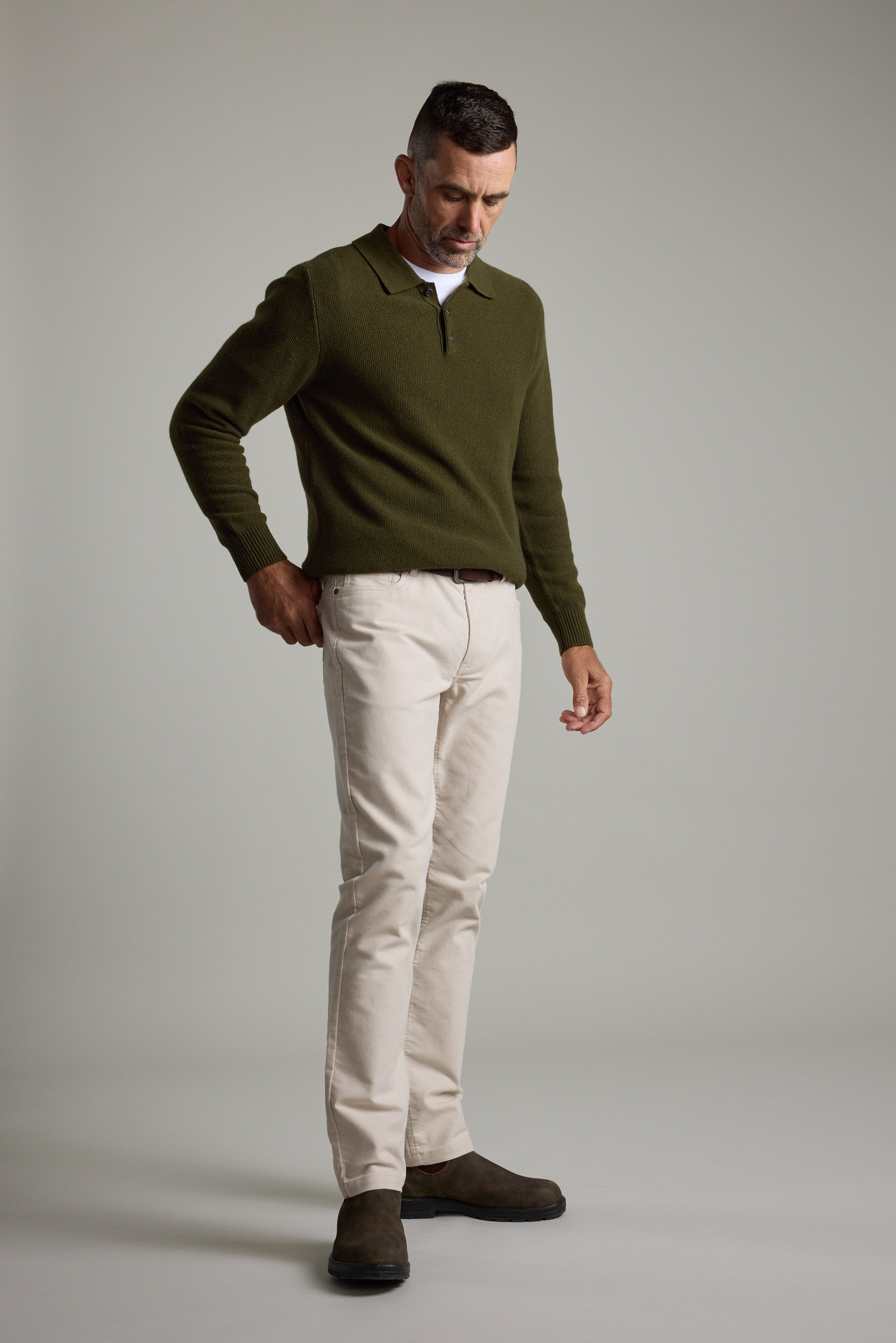 Man wears Barkers Ainsley Woollen Long Sleeve Polo with beige pants and brown boots.
