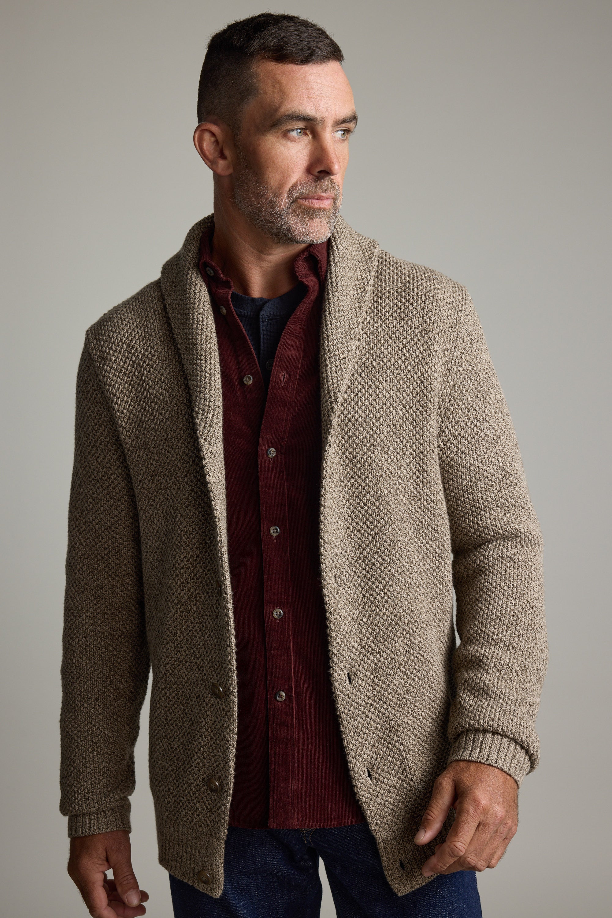 Man wears Rudder Cotton Shawl Cardi by Barkers over maroon shirt, ideal for winter layering.