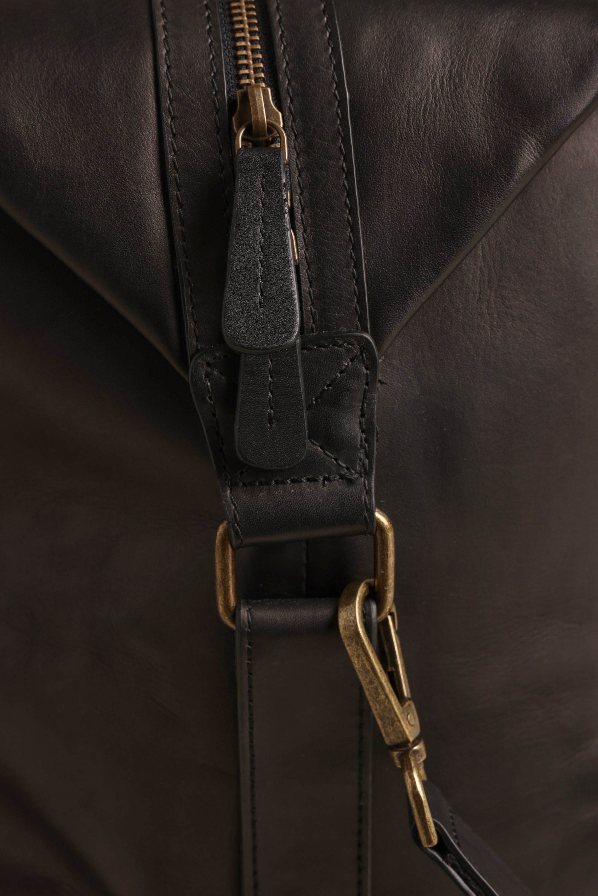 Close-up of the Barkers Costello Leather Weekender, highlighting its premium leather, brass zipper, detailed stitched strap, and metal clasp on a brass ring.