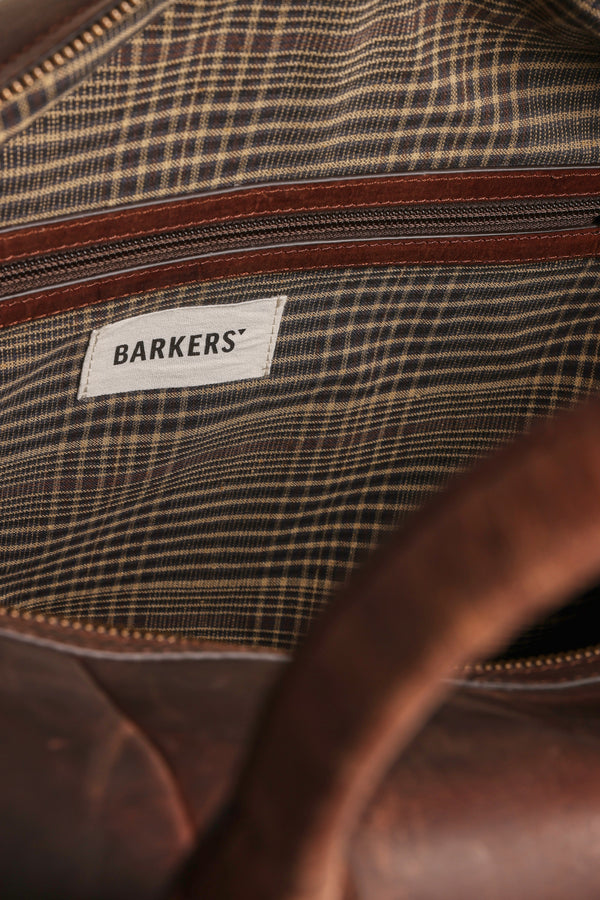 Close-up of the Costello Leather Weekender by Barkers, featuring a striped fabric lining, brown zipper, and a white Barkers label sewn inside.