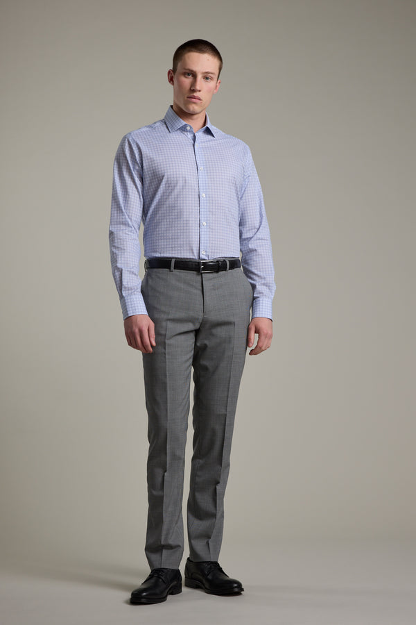 A man stands against a plain background wearing the Barkers Seton Print Business Shirt, paired with grey dress pants, a black belt, and black dress shoes. He faces the camera with a neutral expression.