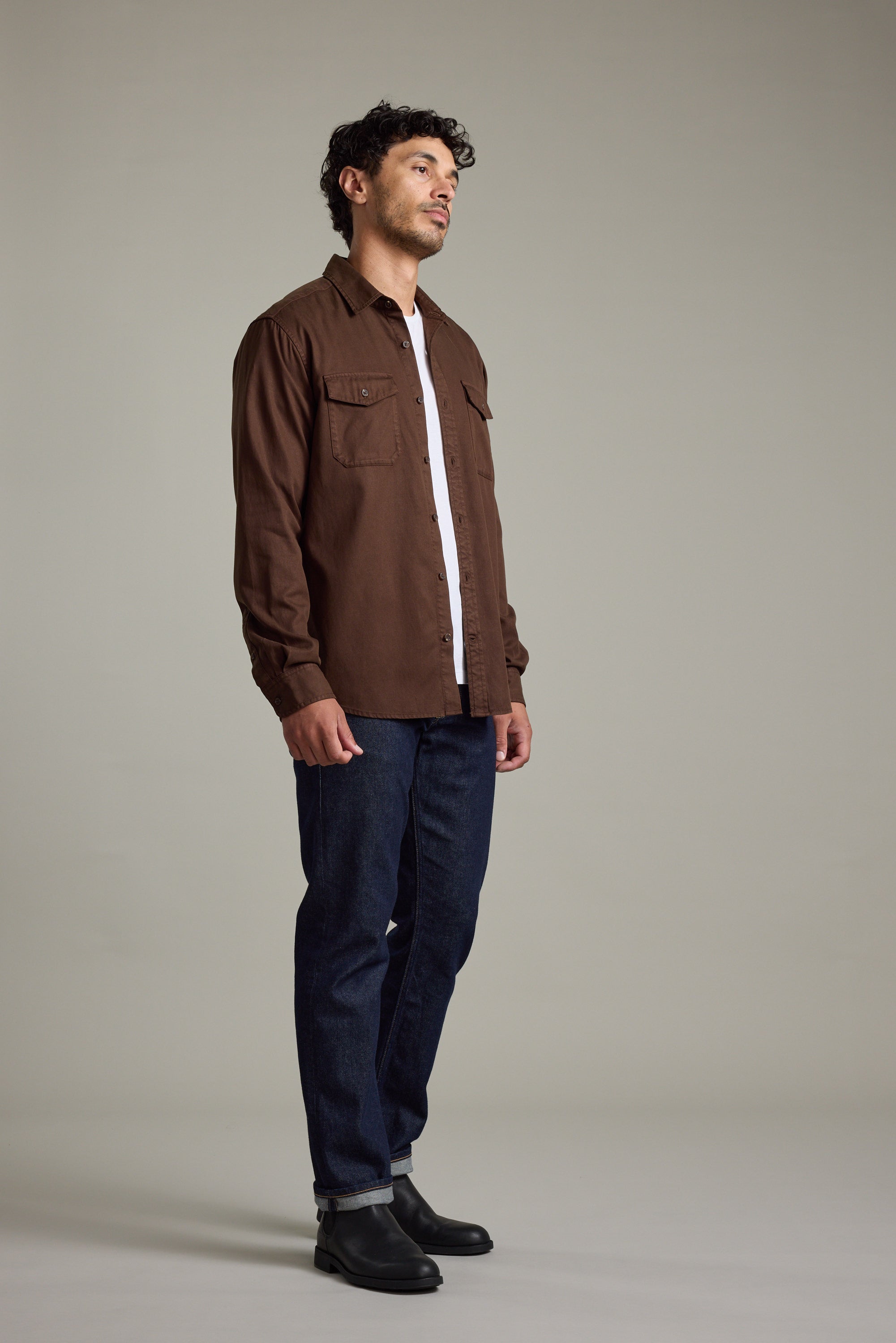 Man in a Barkers Darden Shirt, white tee, blue jeans, and black boots standing sideways.