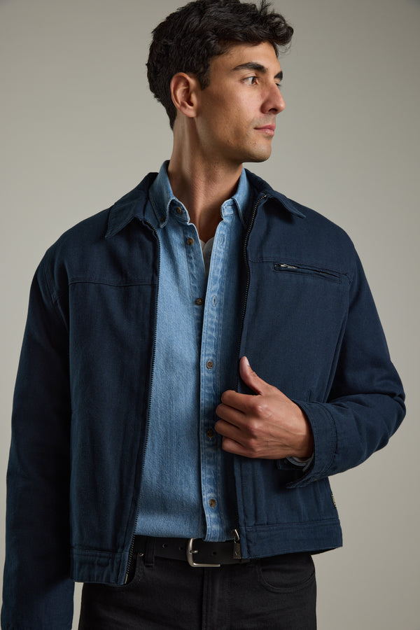 Man in Barkers Avalon Denim Shirt and navy jacket, classic fit, looking to the side.