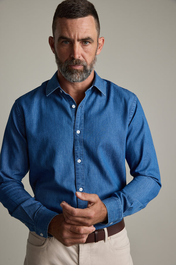 Man with a beard wears Barkers' Wyatt Denim Business Shirt and beige pants against plain background.