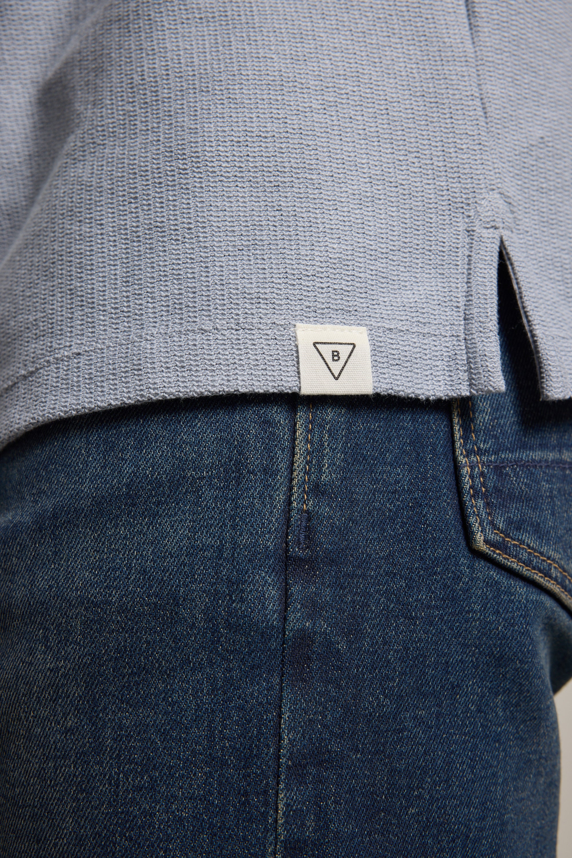 Close-up of Barkers Winfield Textured Polo in light blue, styled with blue jeans.