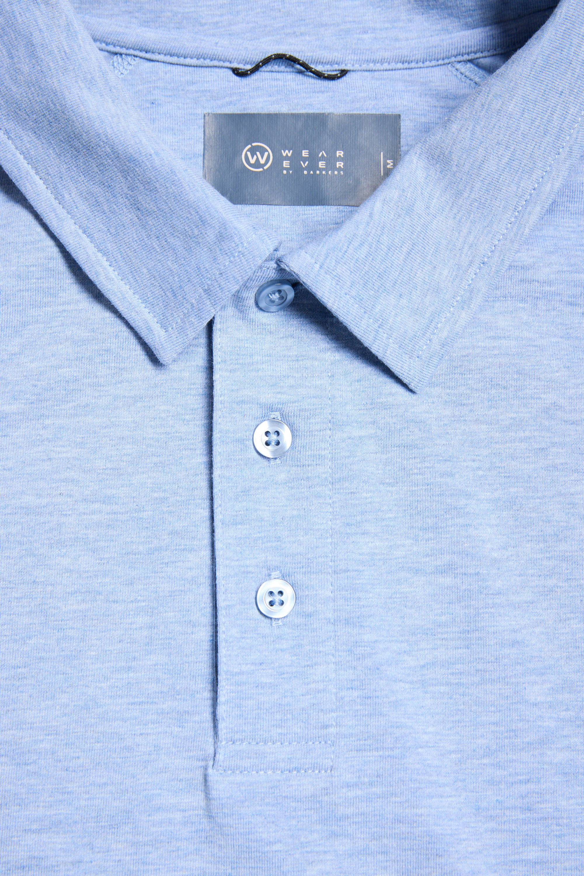 Close-up of a light blue WearEver Outbound Polo with three buttons and a visible neckline label, crafted from breathable cotton-blend fabric for comfort.