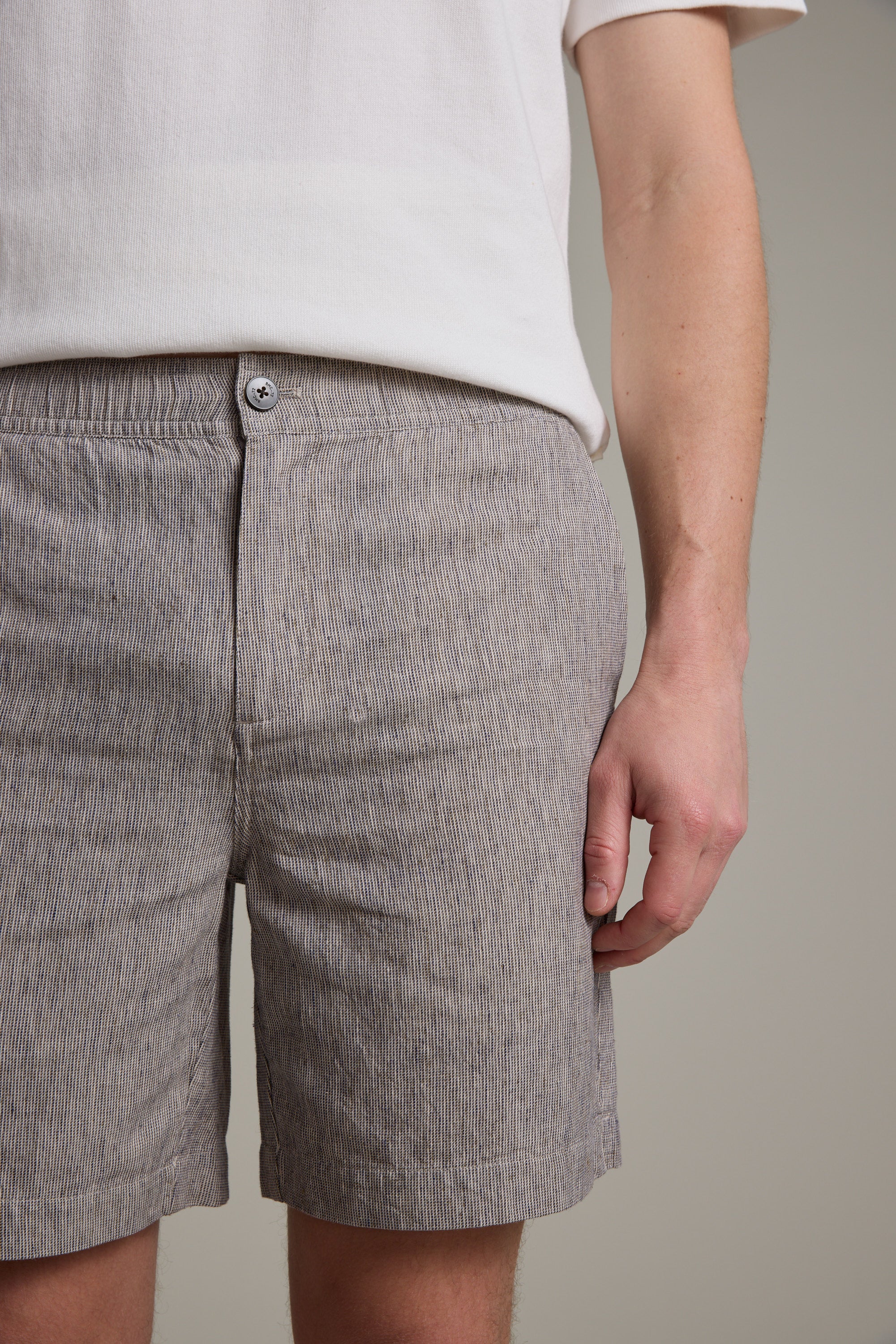 A person in a white short-sleeve shirt and Barkers Woodley Weekend Short, light gray with stripes and an elastic waistband, stands against a plain background. The cropped image shows their torso and upper legs.