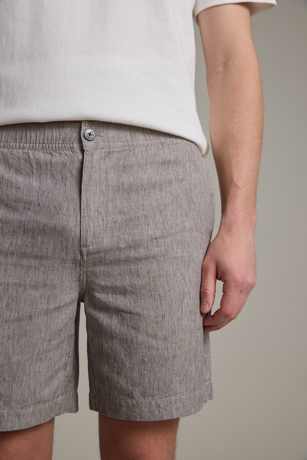 A person in a white short-sleeve shirt and Barkers Woodley Weekend Short, light gray with stripes and an elastic waistband, stands against a plain background. The cropped image shows their torso and upper legs.