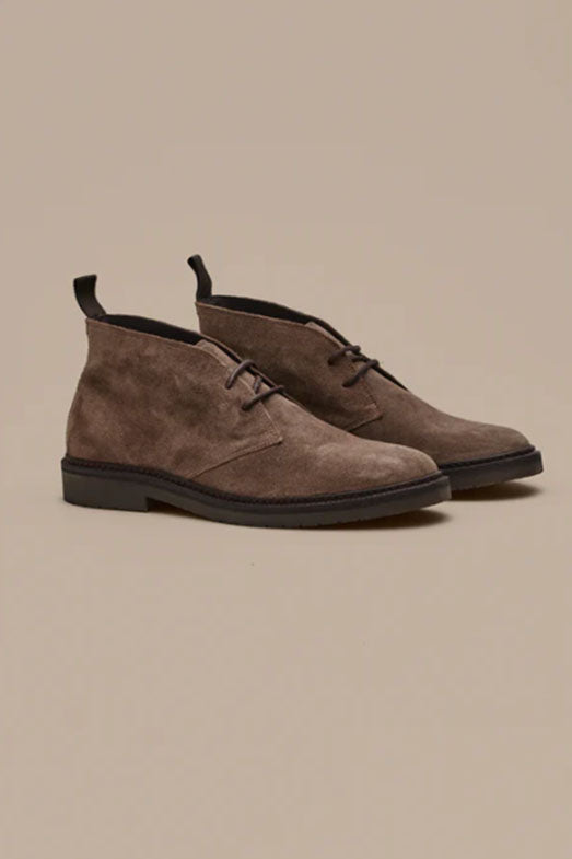 The Barkers Howarth Desert Boot is a pair of brown suede Portuguese footwear with black soles and laces, shown against a plain beige background.