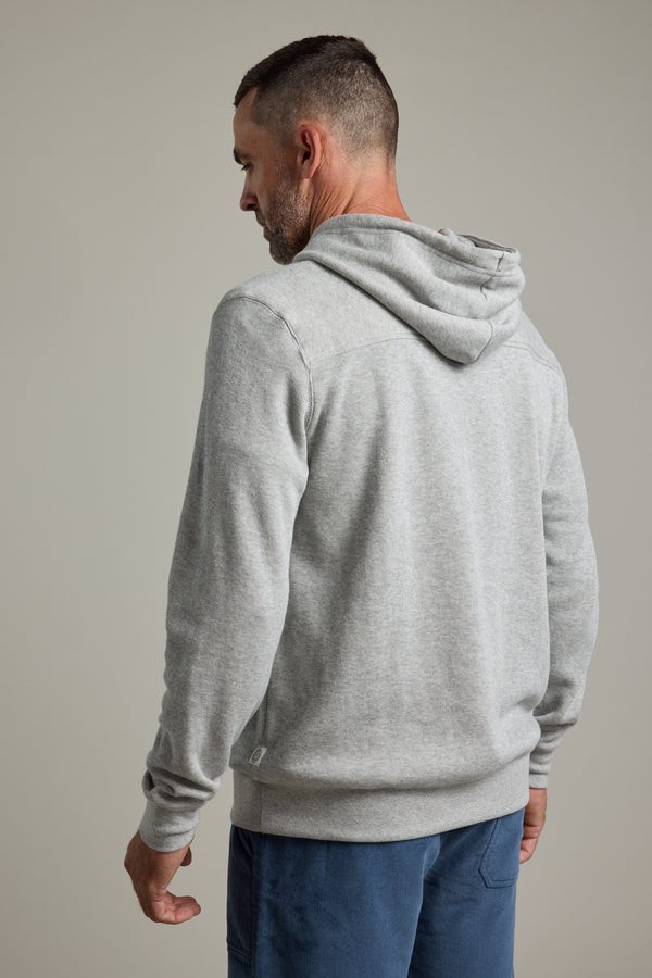 A man with short hair and a beard, facing away from the camera, wears the Barkers Inlet Hoody in light gray and blue pants against a plain background.