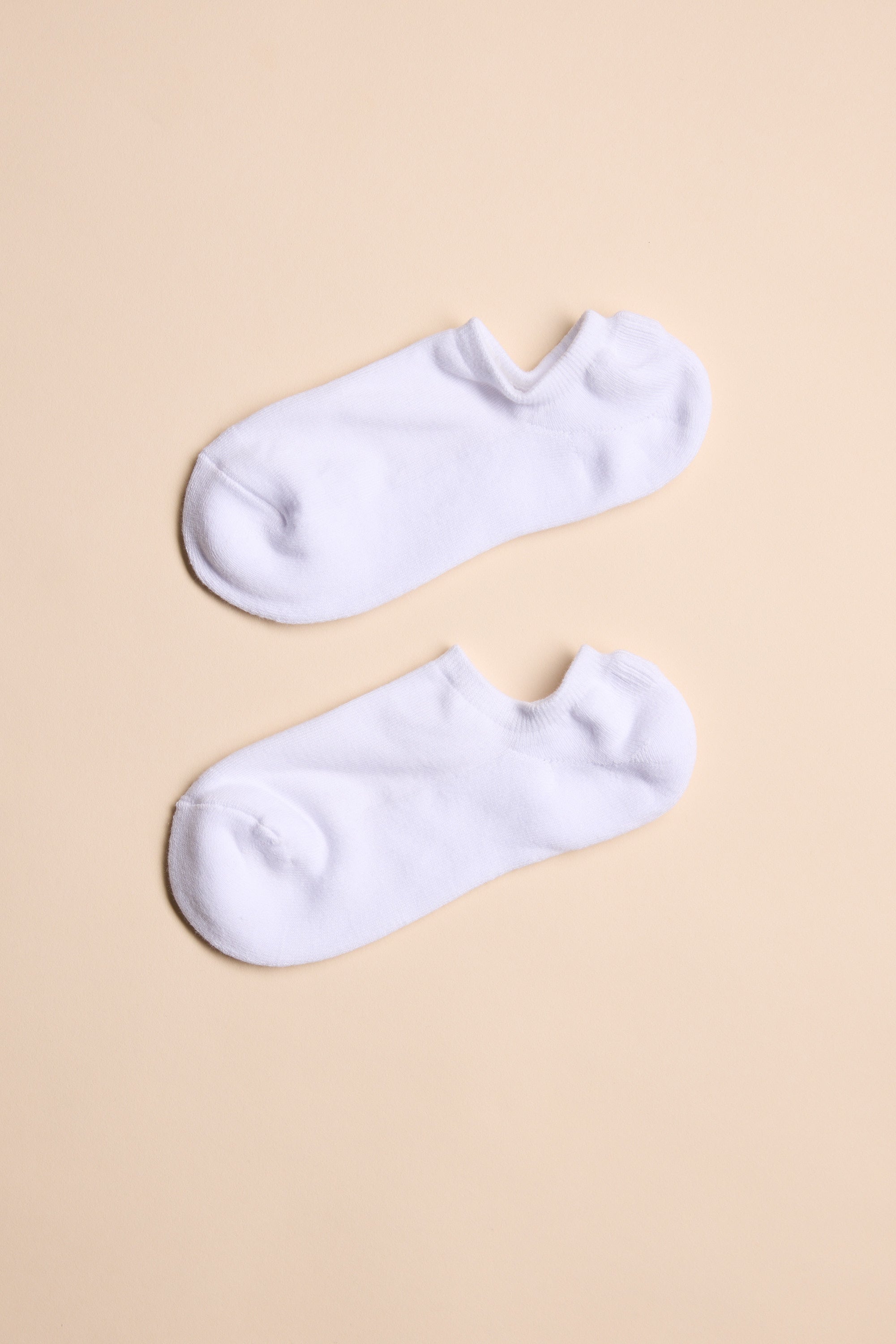 A pair of Barkers Ankle Socks in plain white, crafted from responsibly sourced cotton, laid flat and parallel on a light beige background for all-day comfort. Brand: Barkers.