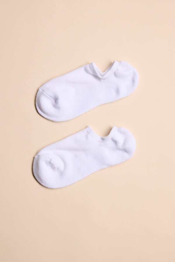 A pair of Barkers Ankle Socks in plain white, crafted from responsibly sourced cotton, laid flat and parallel on a light beige background for all-day comfort. Brand: Barkers.