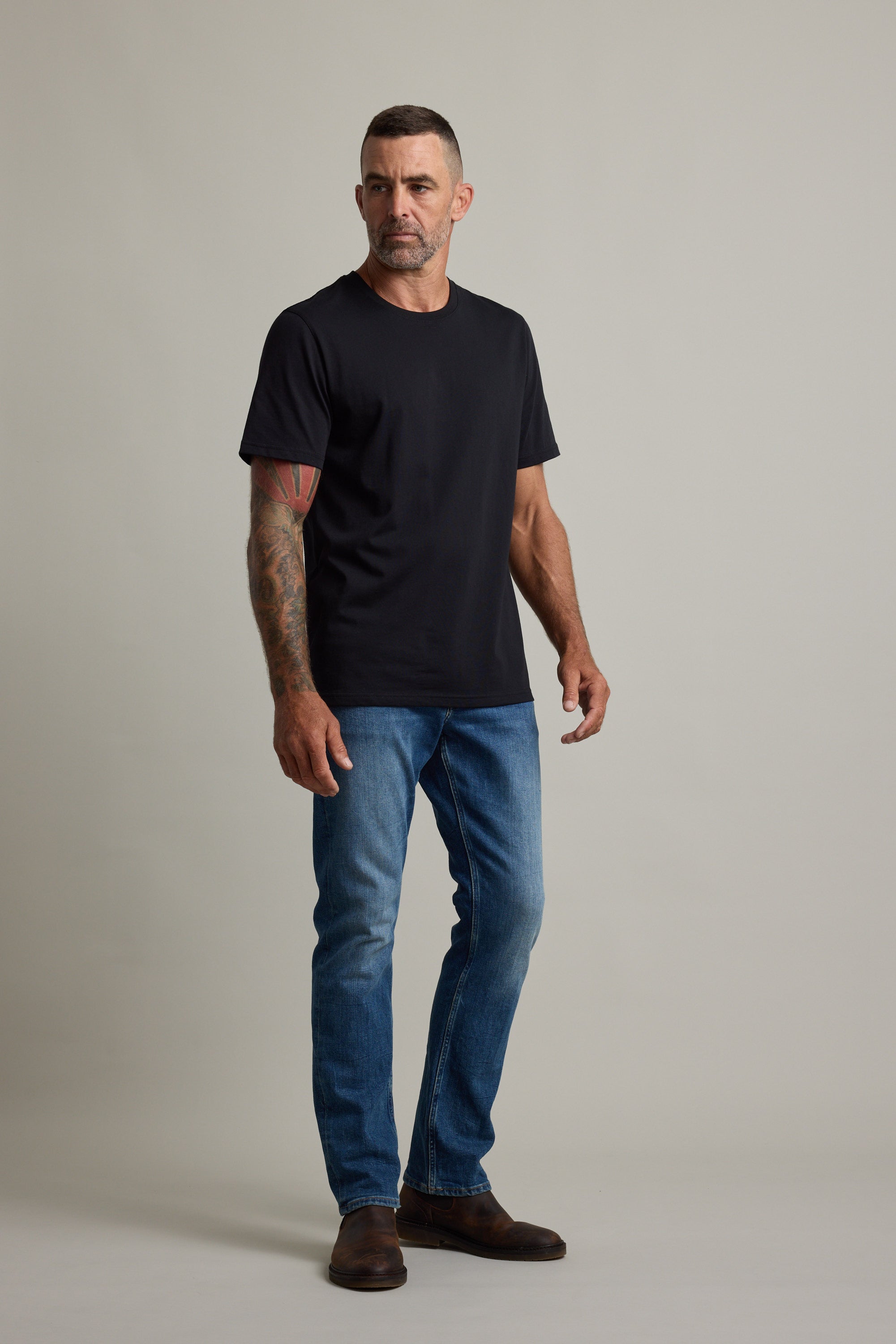 Man in Barkers Good Earth Cotton Essential Tee stands against a plain background.