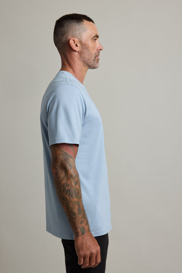 Man with tattoos in a Barkers Good Earth Cotton Essential Tee, profile view against plain background.