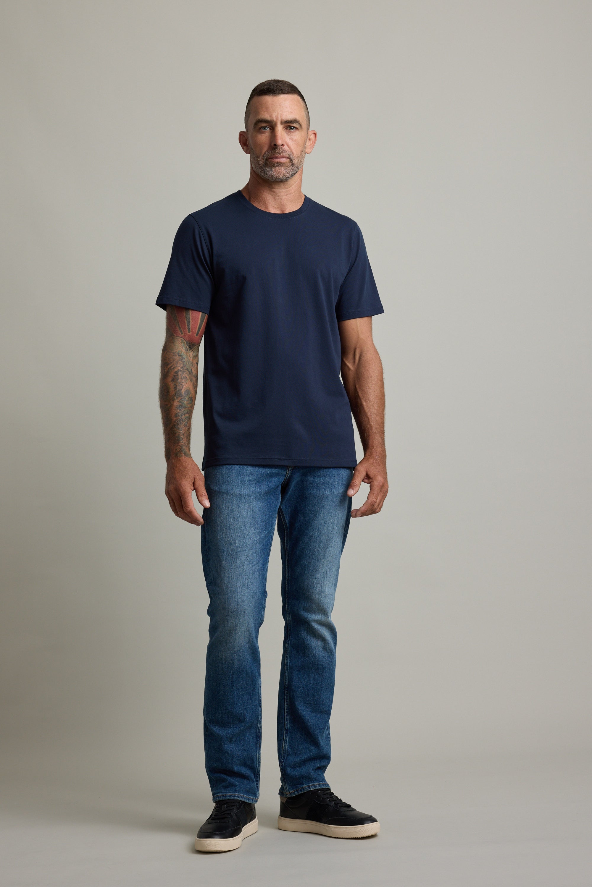 Man with short hair in a Barkers Good Earth Cotton Essential Tee poses confidently.