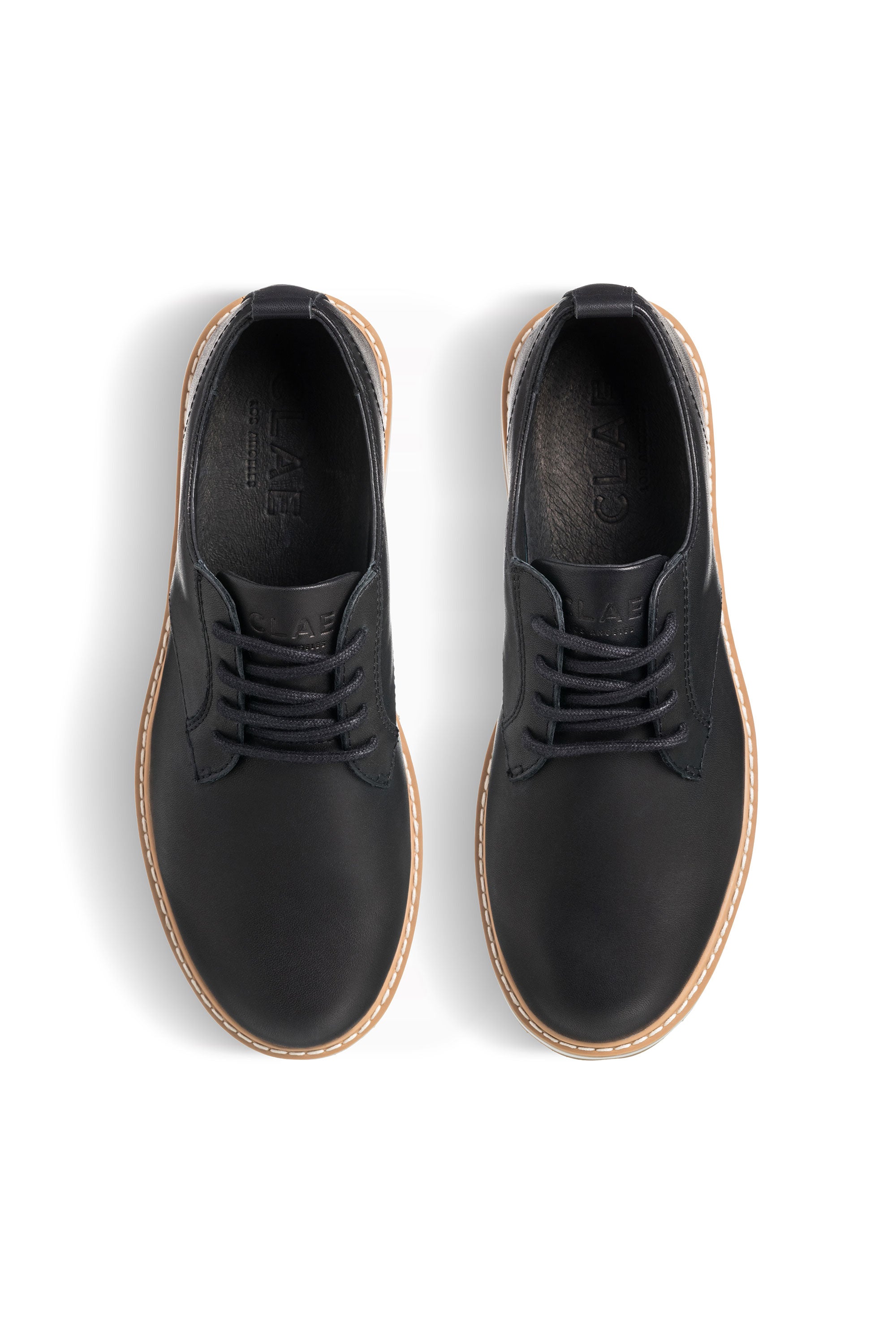 A pair of Clae Logan shoes in premium leather with brown soles, viewed from above on white.