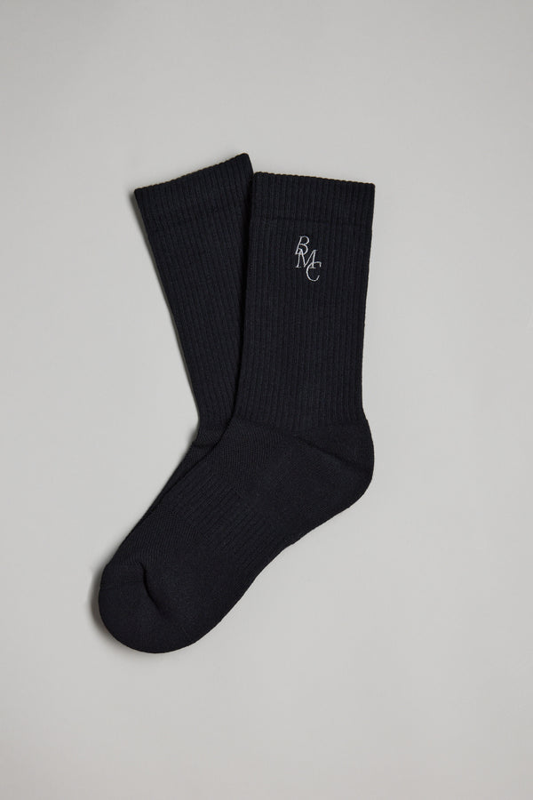 The Barkers BMC Ribbed Sock, in black with a small white BMC logo near the top, is shown in a pair—one placed over the other—on a plain light gray background.