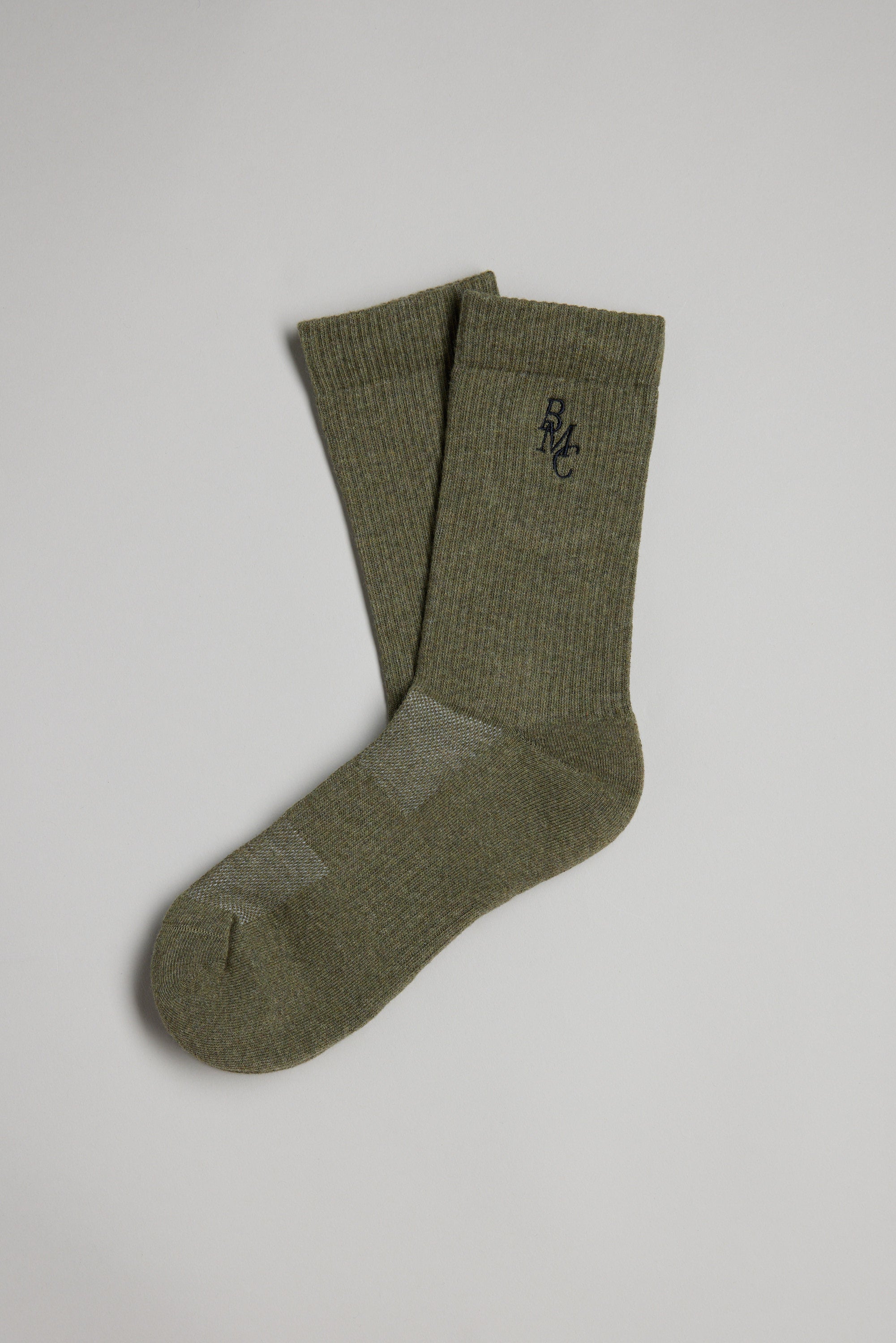 A pair of olive green BMC Ribbed Socks by Barkers, featuring a small black RMC logo on the upper part, are shown overlapped on a plain light gray background.
