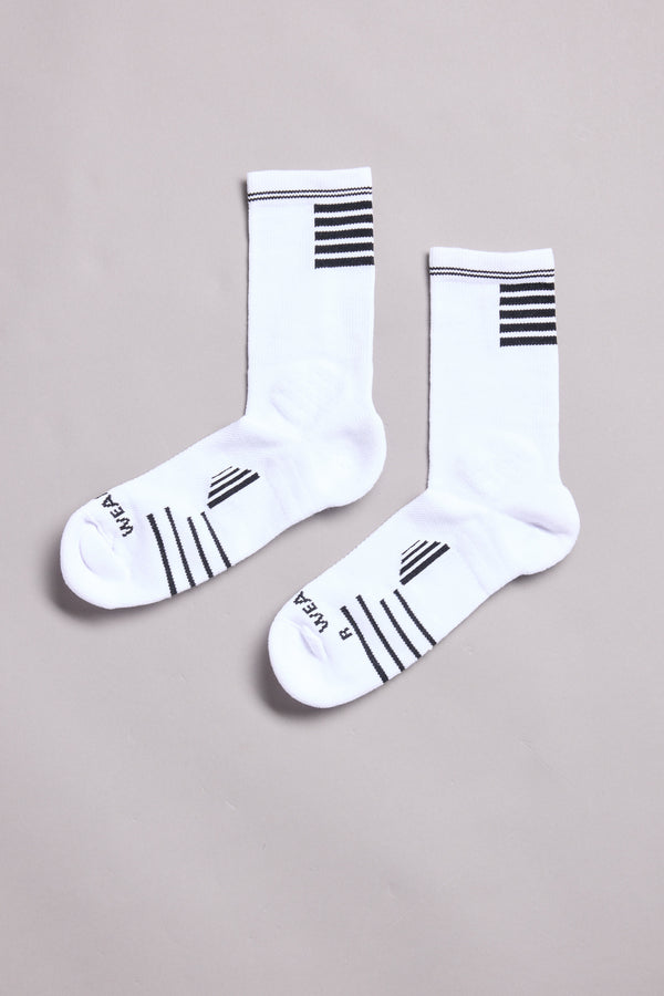 A pair of WearEver Active Socks from WearEver in moisture-wicking white, with black stripes at the top and foot, labeled L WEAR and R WEAR, are laid flat on a light gray background.