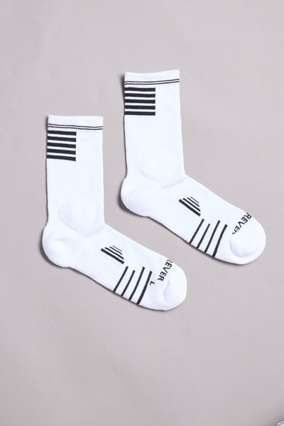 A pair of WearEver Active Socks by WearEver in white crew style, featuring black stripes near the cuffs and toes and "REVER" and "LEVEL" printed on the soles, displayed on a light gray background.