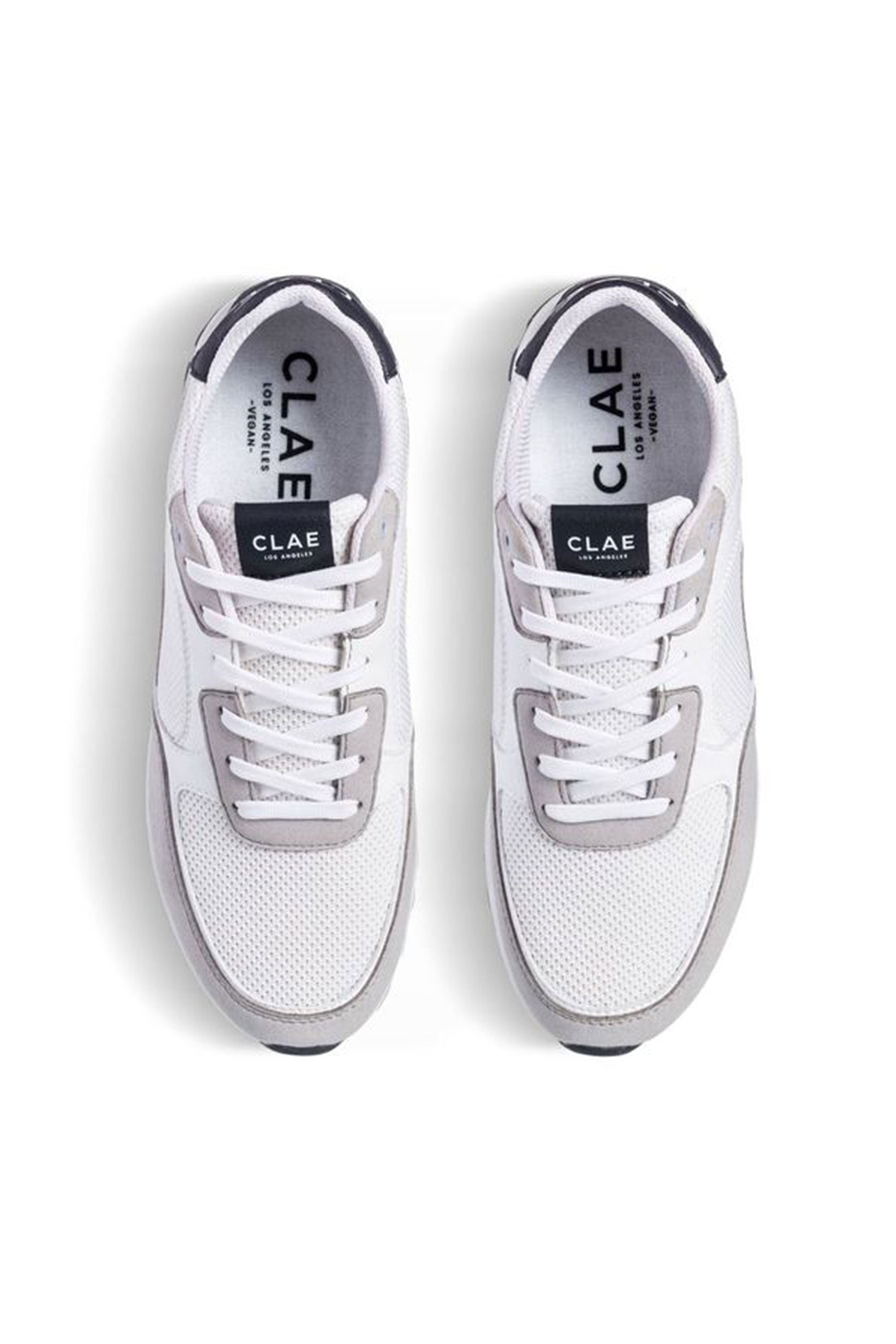 A top view of the Clae - Joshua by Clae shows white and light gray sustainable sneakers with mesh uppers, gray suede accents, white laces, and black branding on the tongue and insole.